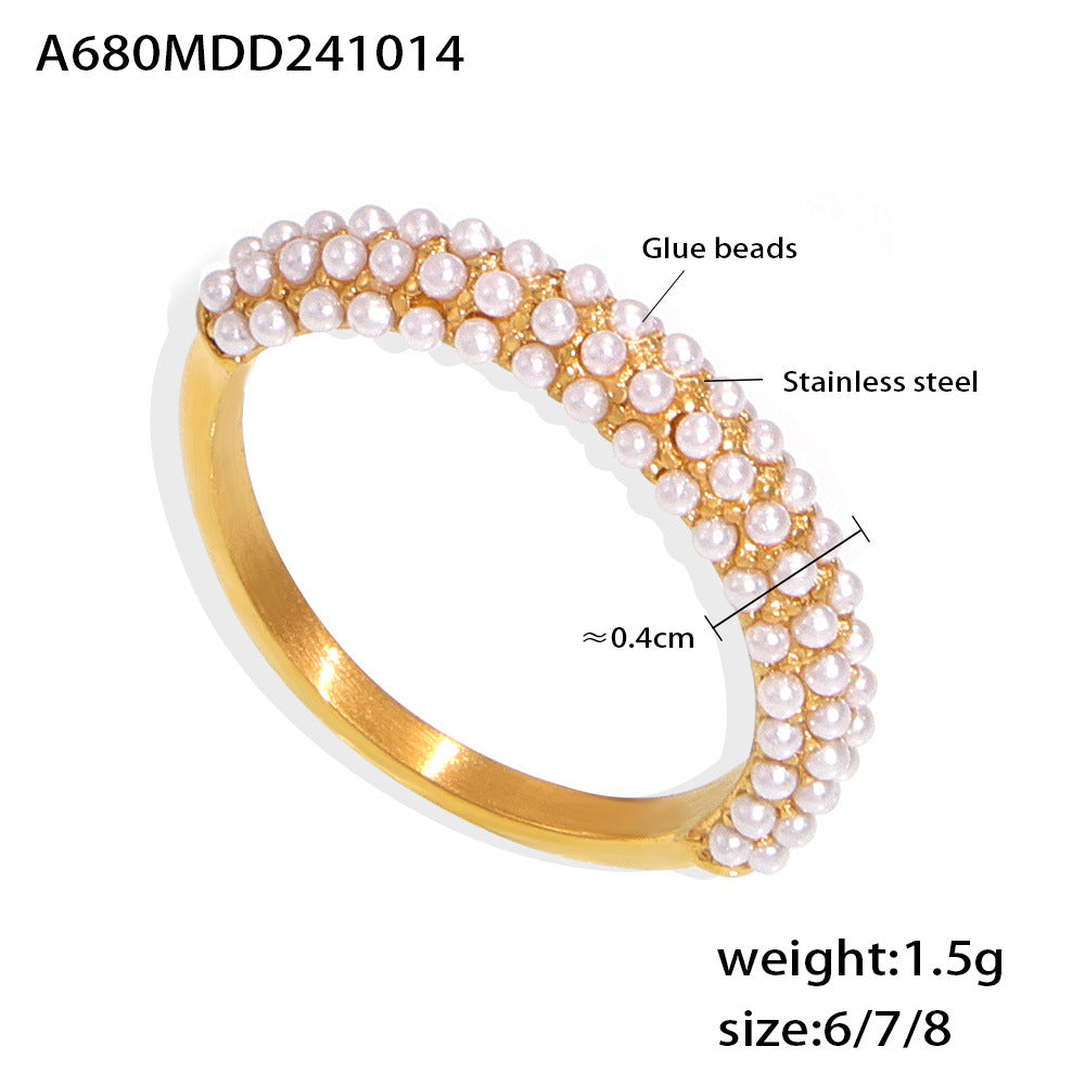 Strovlin 18K gold pearl ring with PVD titanium steel band, unisex jewelry featuring a sleek, polished design and a central pearl.